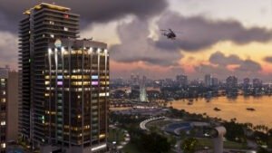 Vice City ao entardecer, com prédios e helicóptero, em captura oficial de GTA VI